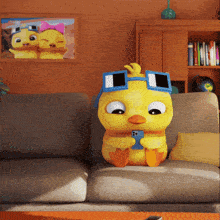 a cartoon duck is sitting on a couch with a cell phone