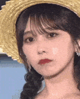 a close up of a woman wearing a straw hat and earrings