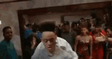 a man in a black hat is dancing in a room with a crowd of people .