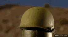 a soldier 's helmet is sitting on top of a watermelon in the desert .