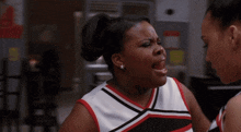 two cheerleaders are talking to each other in a room