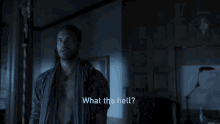 a man in a robe is standing in a dark room and talking to someone .