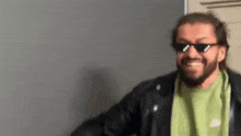 a man with a beard and sunglasses is smiling .