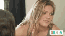 a woman is looking at herself in a mirror and smiling .