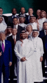 a group of men are posing for a picture and one man has a lanyard around his neck