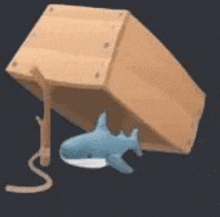 a stuffed shark is hanging from a wooden box .