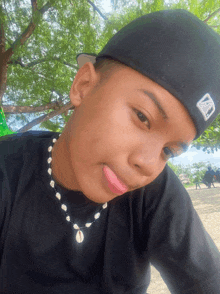 a young boy wearing a black hat with the letter b on it