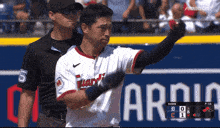 a baseball player with the number 5 on his jersey stands next to a referee