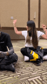 a man and a woman are sitting on the floor with their arms up