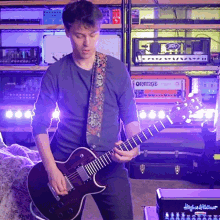 a man is playing a guitar in front of an orange amp