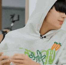 a person wearing a hoodie is holding a cup of coffee .