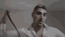 a man in a white shirt is holding a pair of glasses in his hand .