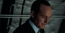 a man in a suit and tie is looking down