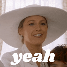 a woman wearing a white hat is smiling with the word yeah above her