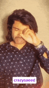 a man with long hair and a mustache is covering his eyes with his hand and the word crazysaeed is above him