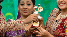 a woman is holding a trophy with the number 1st on it