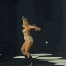 a woman is dancing on a stage with a microphone .