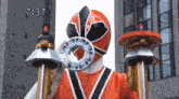 a red power ranger is holding two swords and a ring in his mouth