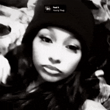 a black and white photo of a woman wearing a beanie with the song feel it young thug playing