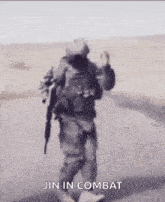 a soldier is walking down a road with a gun in his hand and says `` jin in combat '' .