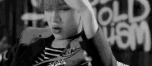 a black and white photo of a person holding their hand to their head .