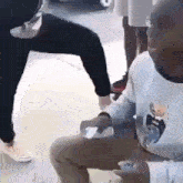 a man in a white shirt is kneeling down next to a woman in black pants .