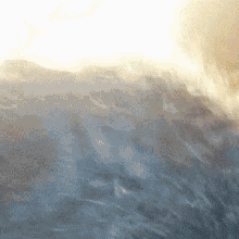 the sun is shining through the clouds over a mountain