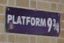 a purple sign that says platform 9 3/4 on a brick wall