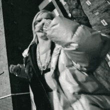 a black and white photo of a woman wearing a puffer jacket