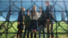 a group of people standing next to each other in front of a fence