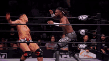 a wrestler is doing a handstand in a ring with a sign that says all elite aew on it