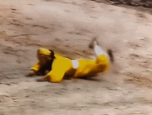 a person in a yellow suit is laying on their back on the ground