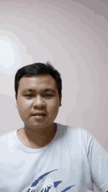 a man wearing a white t-shirt with a picture of a bird on it