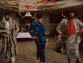 three women are dancing in front of a sign that says ' christmas '