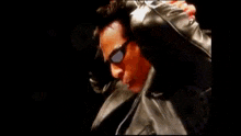 a blurry picture of a man in a leather jacket being punched in the face
