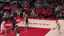 a basketball game is being played on a court with a xfinity logo on the floor