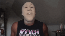 a man with a mask on his face is wearing a kori shirt