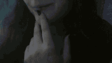 a close up of a woman 's face with her hands covering her mouth