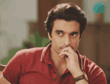 a man wearing a red polo shirt and a watch