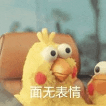 a stuffed chicken with big eyes is sitting next to another stuffed chicken in a car .