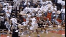 a basketball game is being played in front of a crowd and a sign that says accn