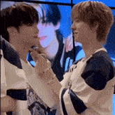 a couple of men are standing next to each other and holding hands .