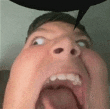 a man is making a funny face with his mouth open .