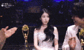 a woman in a white dress is sitting next to a man in a tuxedo with kbs written on the bottom