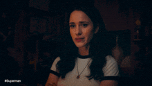 a woman 's face is shown in a dark room with the caption #superman