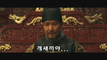 a man in a black hat is sitting in front of a dragon decoration