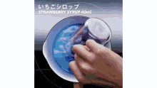 a person is pouring strawberry syrup into a bowl .