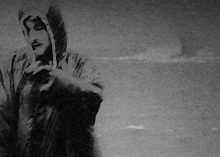 a black and white photo of a man with a hood