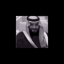a black and white photo of a man with a beard wearing a turban