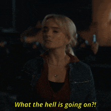 a woman in a denim jacket is asking what the hell is going on